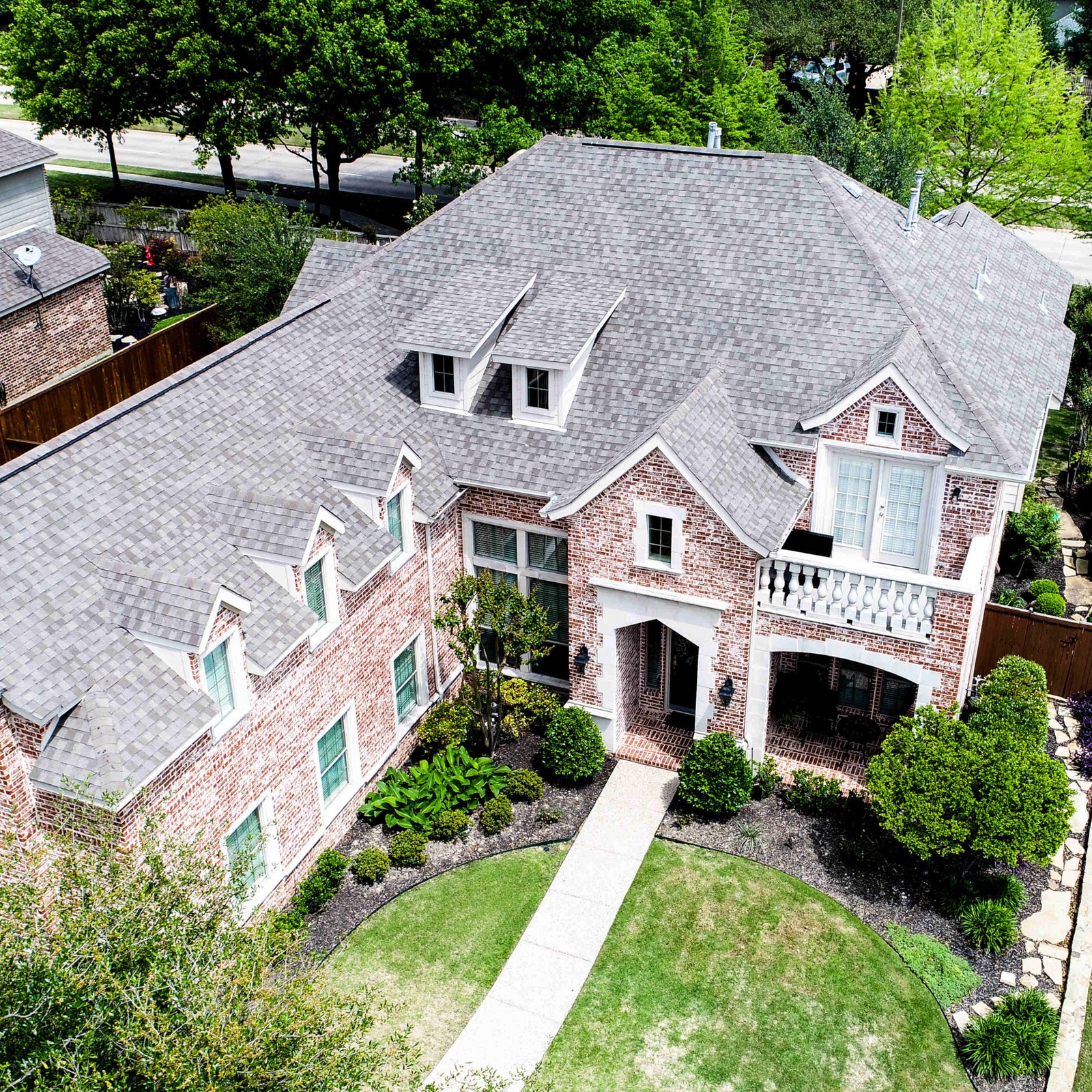 Aerial view of a completed Heritage shingle roof on a Texas brick home